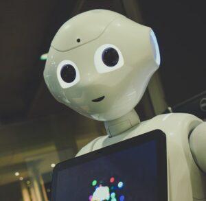 white robot toy holding black tablet
