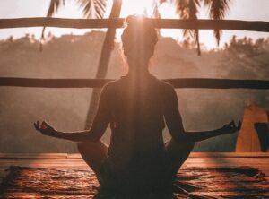 woman doing yoga meditation on brown parquet flooring